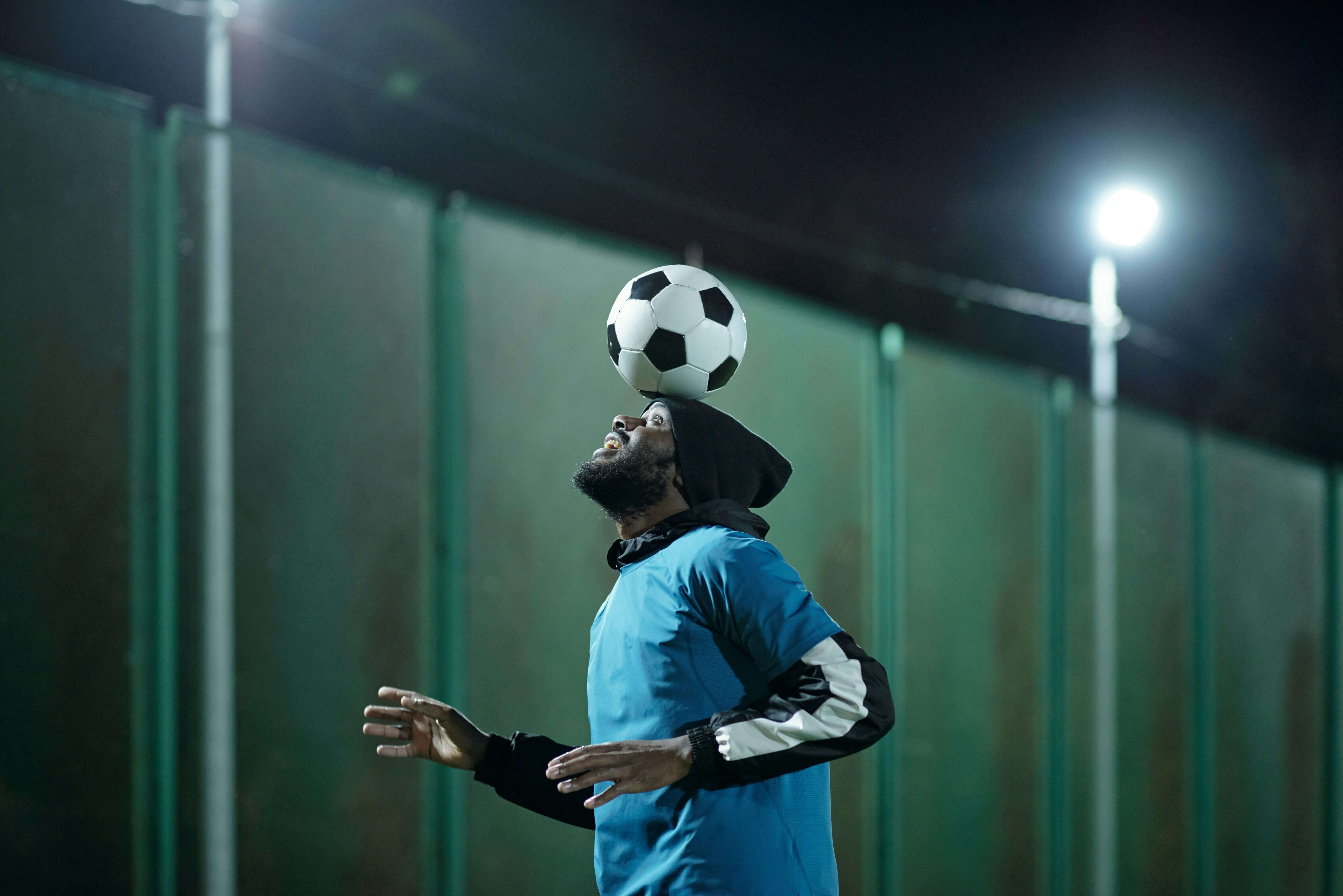 Man balancing football ball on head - homepage image